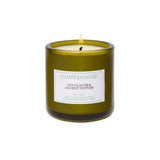A Flamingo Estate Douglas Fir & Ancient Vetiver Candle in an olive-green glass jar with a seafoam label, on a white background.
