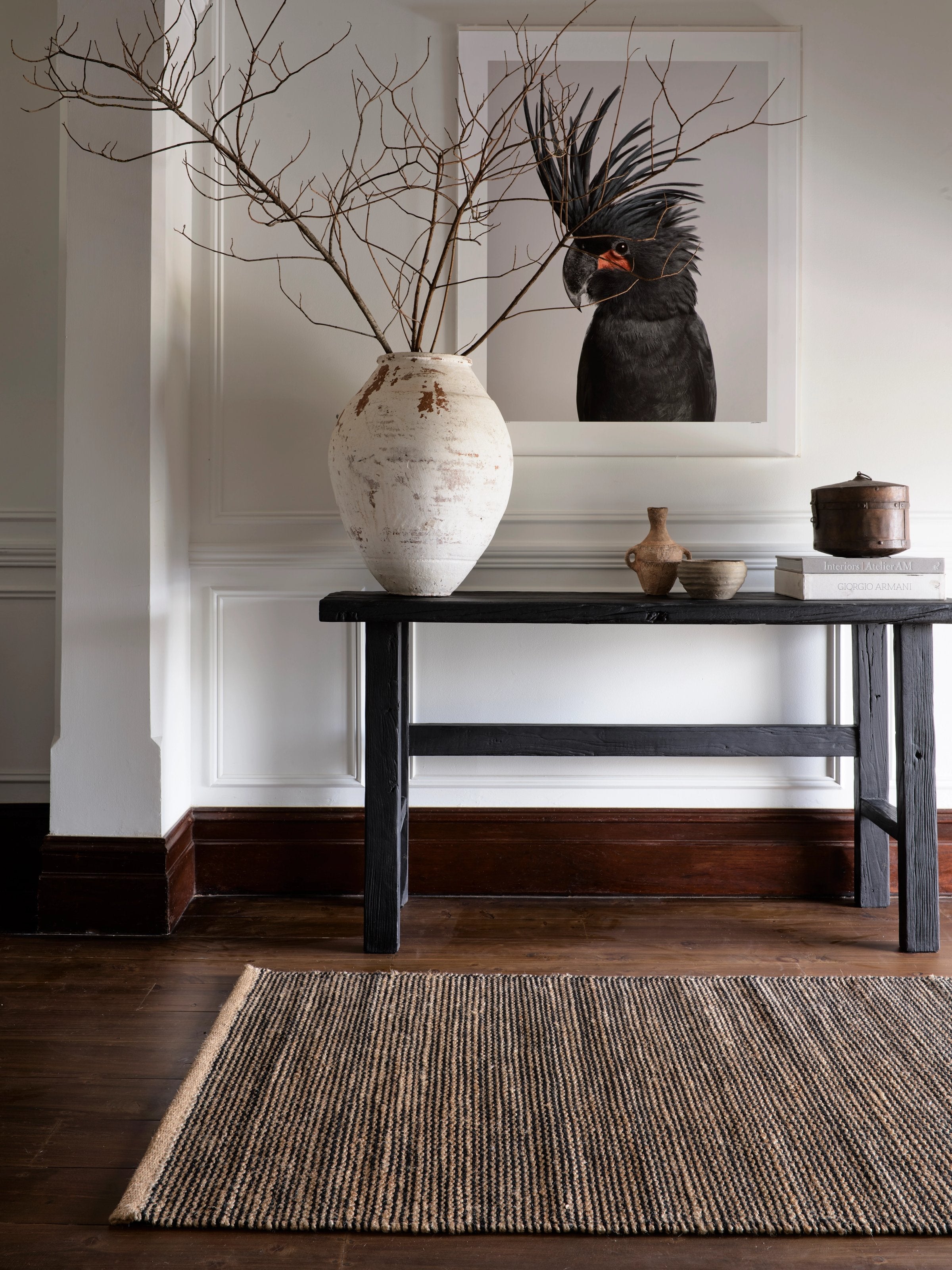 Armadillo Drift Nook Rug in Natural & Black, handwoven jute and wool rug shown in a room setting