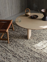 Armadillo Faroe Rug in Muscovado, hand-knotted undyed wool rug shown in a room setting