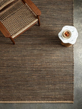 Armadillo Drift Rug in Natural & Black, a second view of the handwoven jute and wool rug in a styled interior