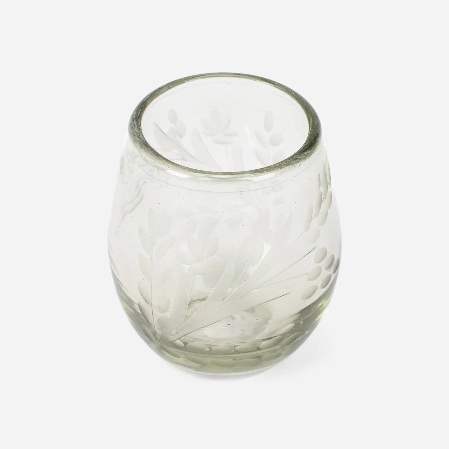 The Etched Oval Glass is a clear, rounded tumbler with an etched floral pattern. This artisanal drinkware piece is shown empty against a plain white background.