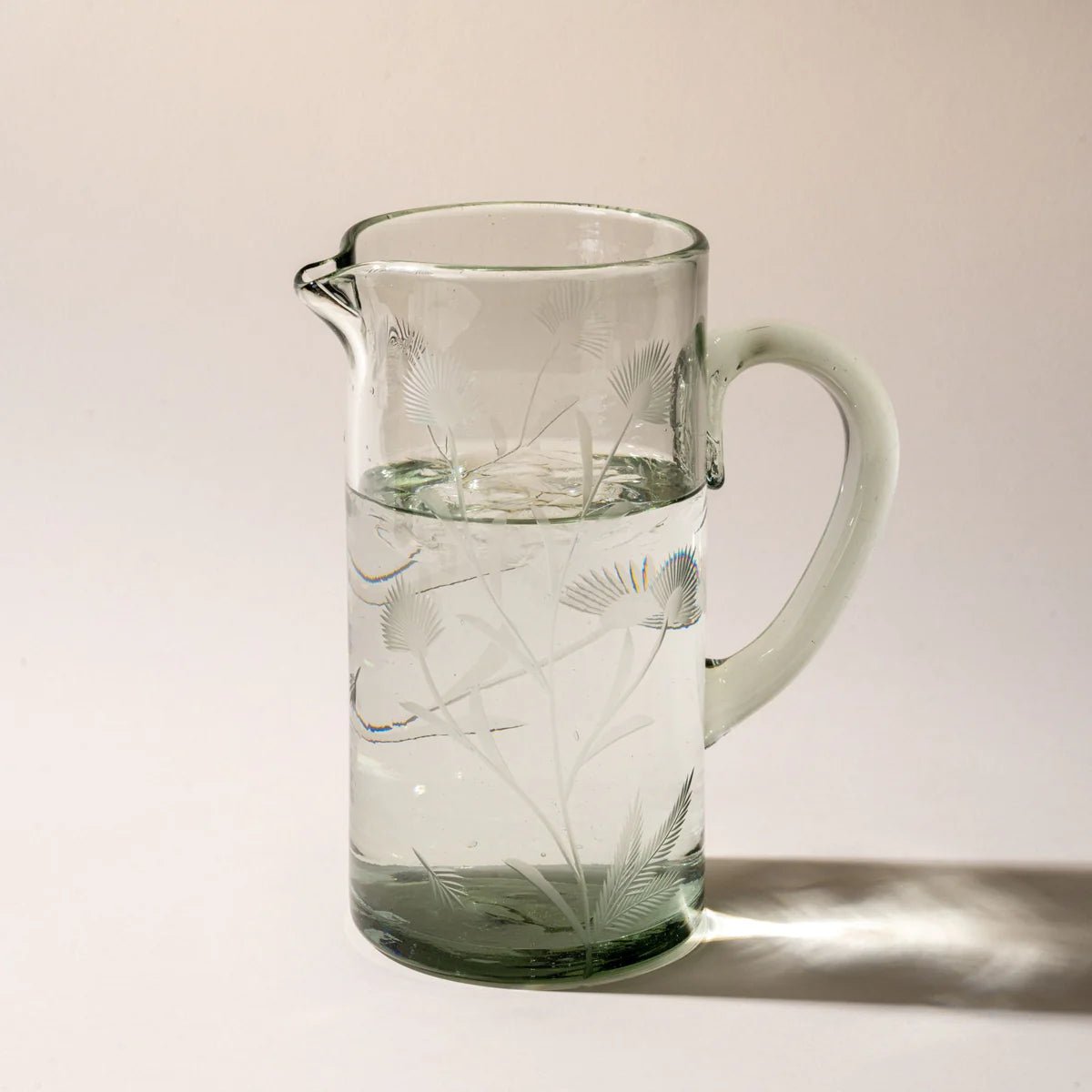 The etched thistle glass pitcher on a neutral surface