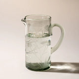 The etched thistle glass pitcher on a neutral surface
