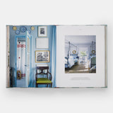 Calimia Home Everybody Loves Stripes book open to a spread showing a blue striped hallway and canopy bedroom.