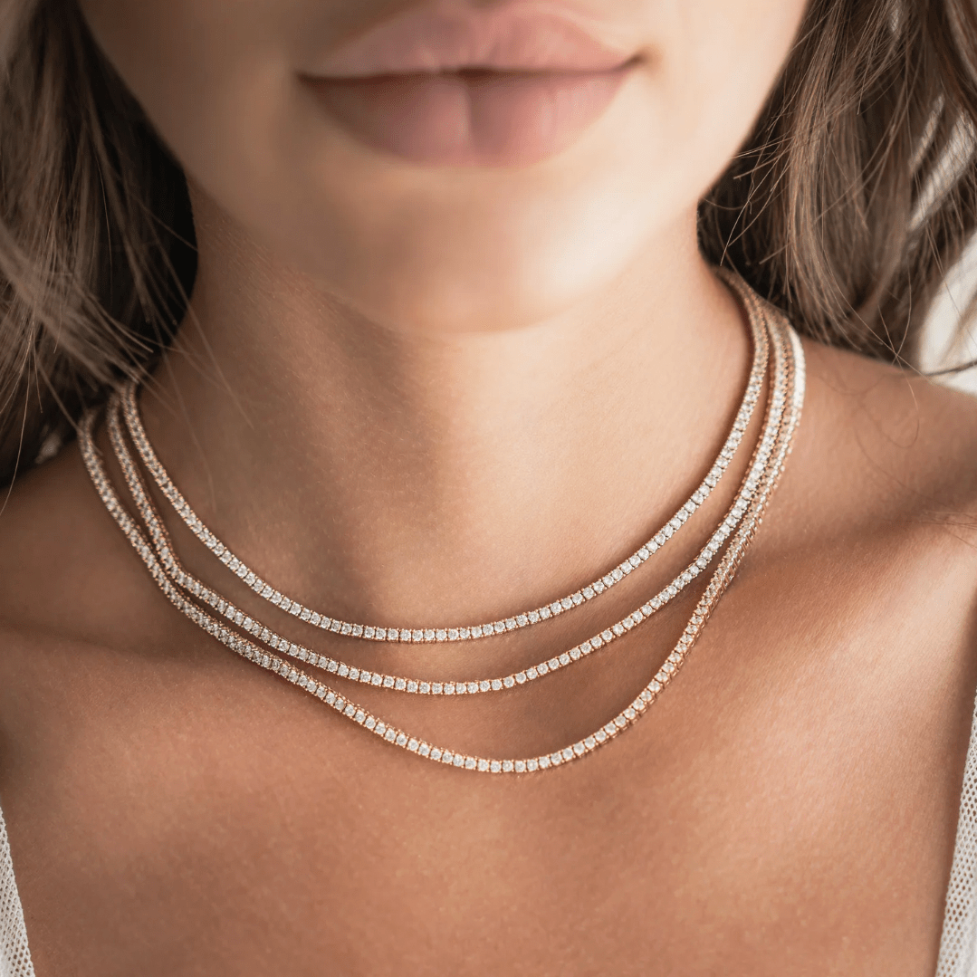 Close-up of yellow gold tennis necklace showing crystal strand detail