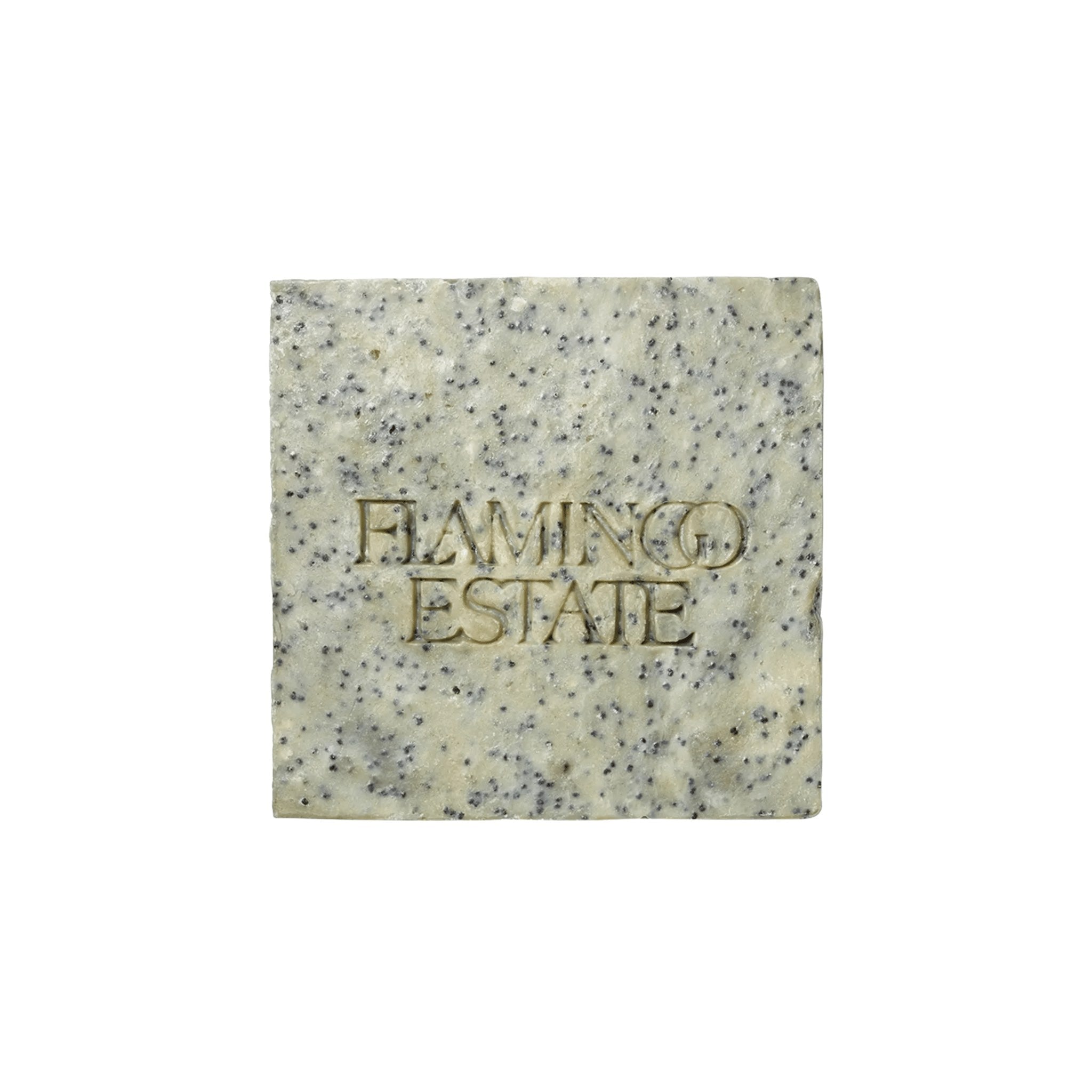 A pale square Flamingo Estate Exfoliating Peppermint Organic Bar Soap embossed with the brand wordmark, flecked with blue clay and sea salt, on a white background.