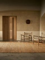 Armadillo Nest Rug in Natural, handwoven jute flatweave rug shown in a room setting