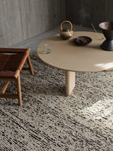 Armadillo Faroe Rug in Muscovado, hand-knotted undyed wool rug shown in a room setting