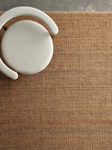 Armadillo Nest Rug in Natural, a second view of the handwoven jute flatweave rug in a styled interior