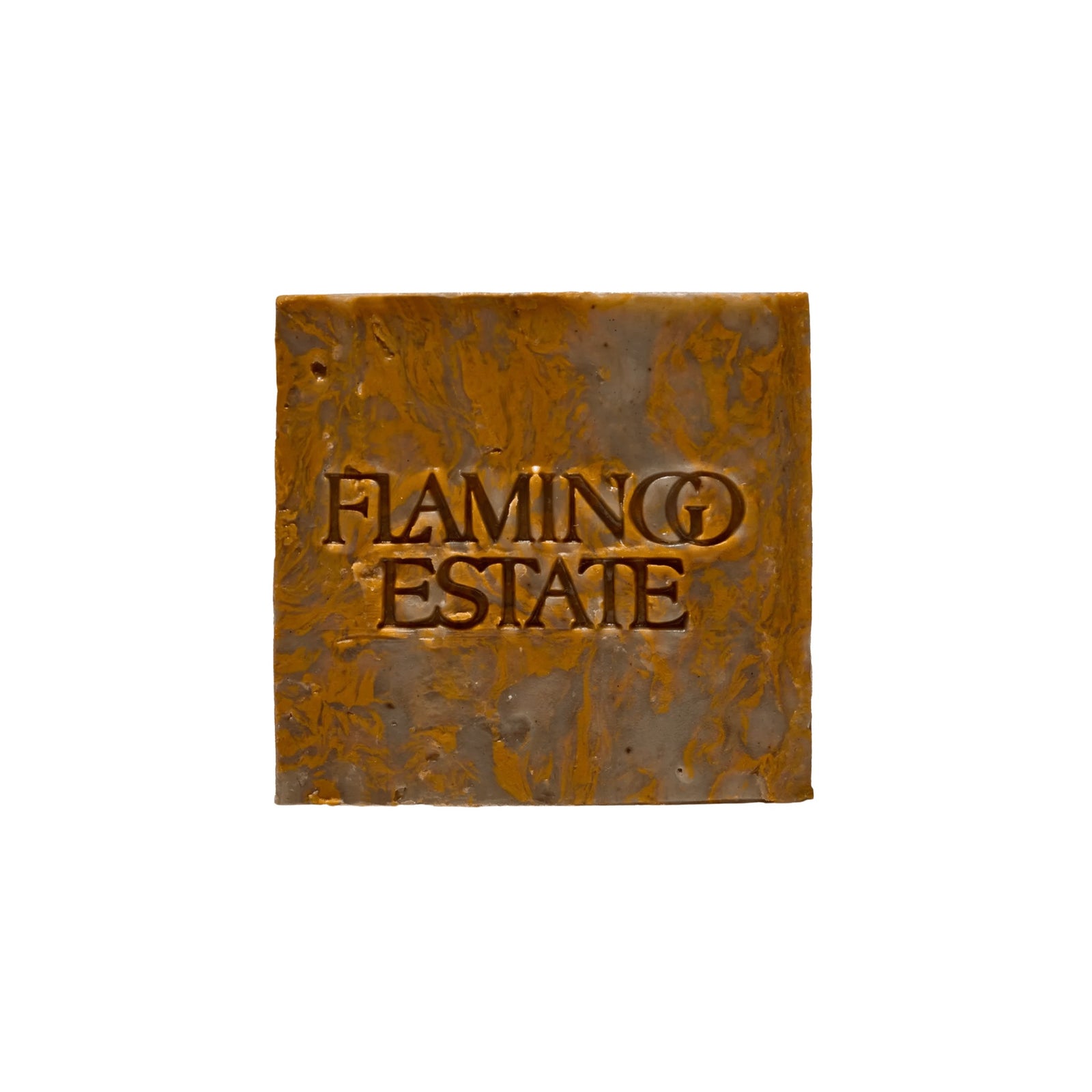 The marbled olive and amber Green Goddess Soap Bar from Flamingo Estate, embossed with the brand wordmark, photographed centered on a white backdrop.