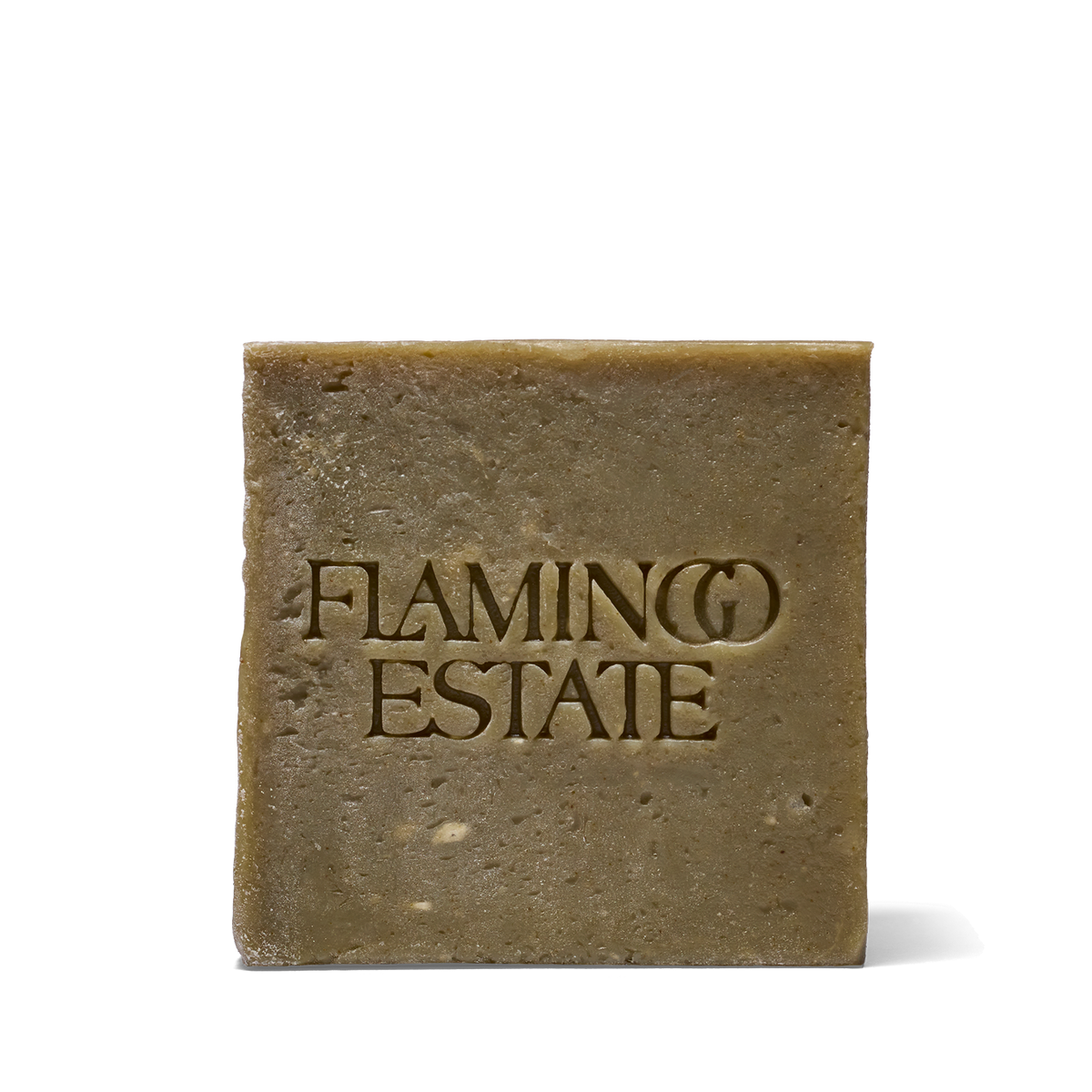 The olive-green Flamingo Estate Rosemary & Parsley Soap Brick, flecked with herbs and embossed with the brand wordmark, on a white background.