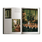 An interior spread of the Flamingo Estate cookbook displays a glowing wall of lit candles surrounding a wildflower bouquet at the Los Angeles estate.