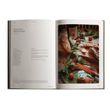 The cookbook is open to Richard Christiansen's Adaptogenic Mushroom Pate recipe, the finished dish styled on a wooden board with arugula and cherry tomatoes.