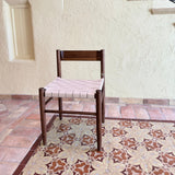 Calimia Home Gaon chair featuring a dark walnut wood frame and a woven cream leather seat in a modern sculptural design