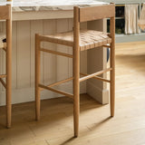 Flag Counter Stool in white oak and woven natural leather pulled up to the marble kitchen island