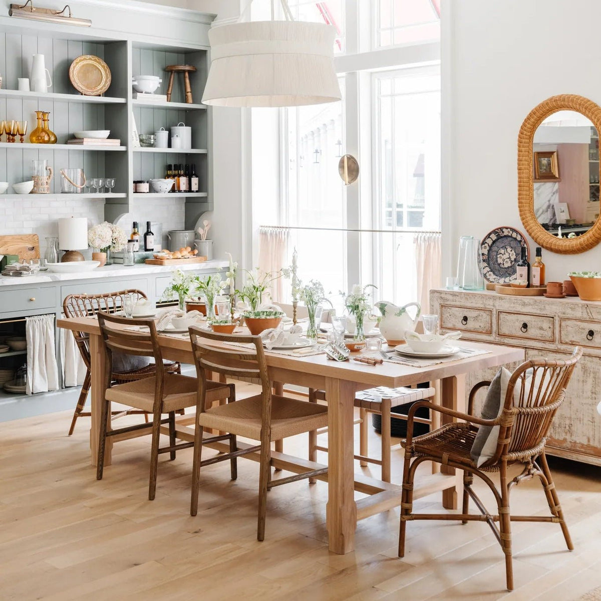 Cassidy Chandelier over a long oak dining table with Glenmore chairs and Retro Rattan arm chairs in the kitchen