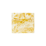 Flamingo Estate Pollinator Bath Soap Brick with a marbled honey and cream finish and embossed Flamingo Estate logo.