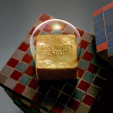 Flamingo Estate Pollinator bath soap brick with Flamingo Estate branding, resting on a mosaic tile surface under a bubble.