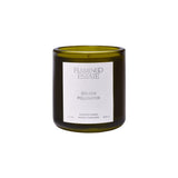 Flamingo Estate Golden Pollinator soy wax candle in a dark olive green glass jar with a white minimalist label.