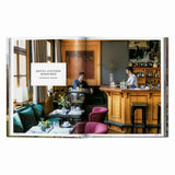 Calimia Home Great Escapes Alps book open to the Hotel Gasthof Hirschen spread with a wood-panelled bar and dining room.