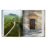 Calimia Home Great Escapes Italy book showing a vineyard landscape and a rustic stone building entrance