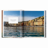 Calimia Home Great Escapes Mediterranean book open to a page showing the colorful coastal village of Punta Chiappa Italy