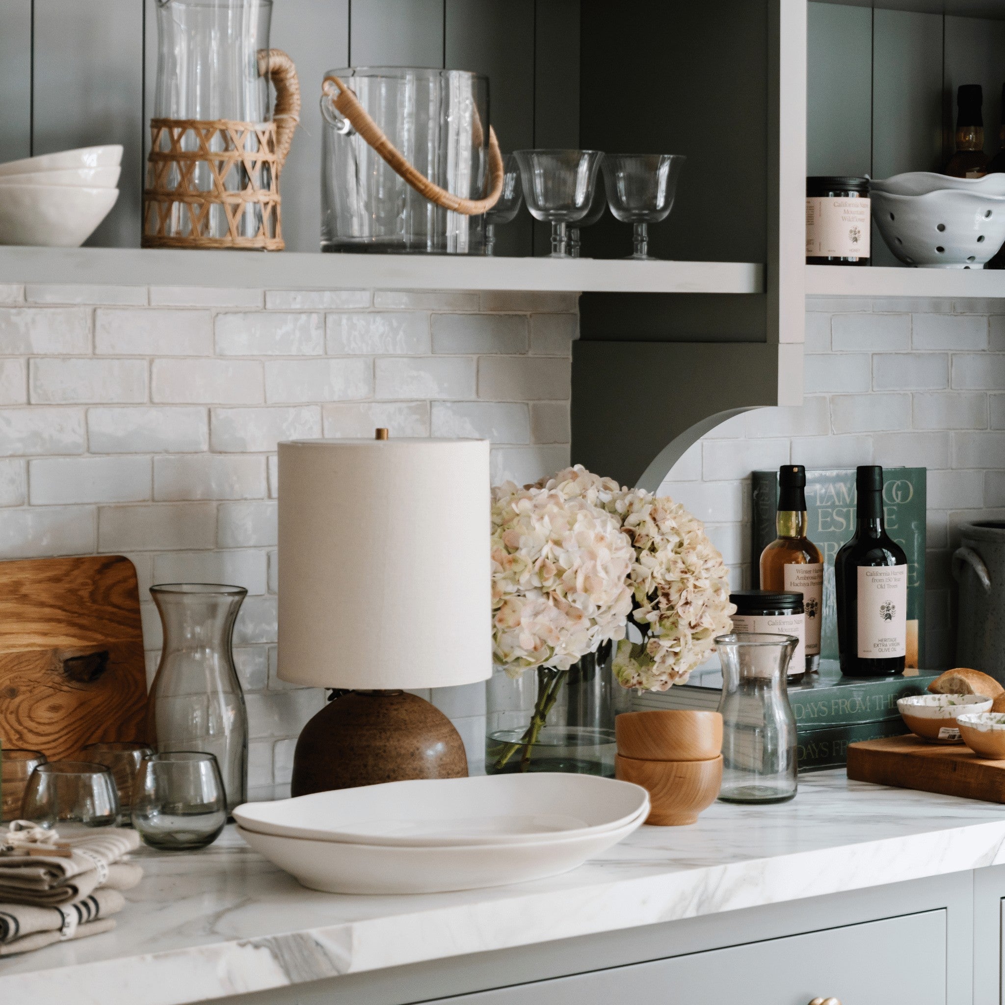 Calimia Home Roli Poli stemless glasses made from clear hand-blown recycled glass on a kitchen counter.