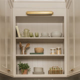 Calimia Home handwoven rattan and bamboo glassware holder displayed on a kitchen counter in a neutral pantry setting.