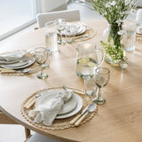 Pom Pom At Home Healdsburg Napkins in ocean blue with thin stripes and fringe edges set on a wooden dining table.