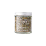 Calicutts Herbes De Provence spice blend in a clear glass jar with a silver lid, featuring dried thyme and lavender.