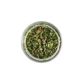 Calicutts Herbs Blend in a glass jar, featuring a mix of dried green aromatic herbs for seasoning.