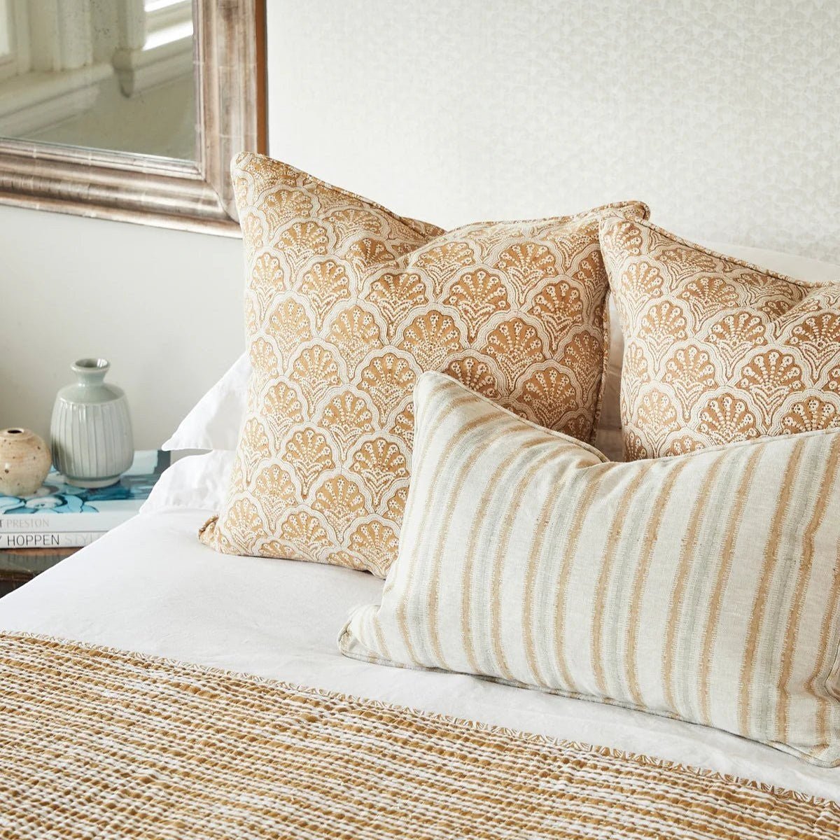 Walter G Indira Elm lumbar pillow with irregular hand block-printed stripes and piped edges on a bed.