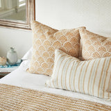 Walter G Indira Elm lumbar pillow with irregular hand block-printed stripes and piped edges on a bed.