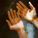 Two wet hands held palms up, lathered in Flamingo Estate Jasmine Damask Rose Castile hand soap.