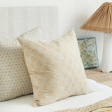 Walter G Kumasi Elm linen pillow with hand block printed grid pattern in neutral tones on a bed.