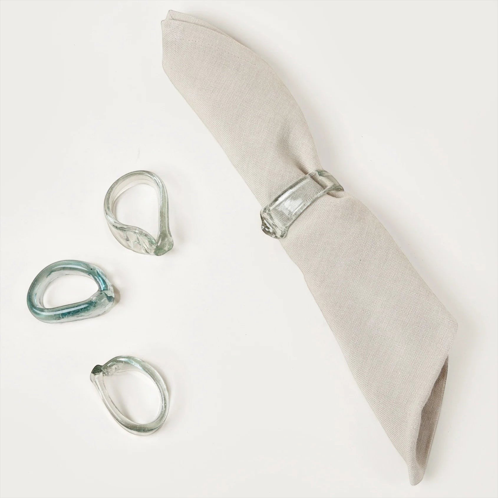 Sculptural Italian glass napkin ring on a folded linen napkin