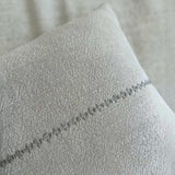 One Bi One Close-up detail of the Lea Pillow showing the hand-embroidered line pattern on natural beige Belgian linen