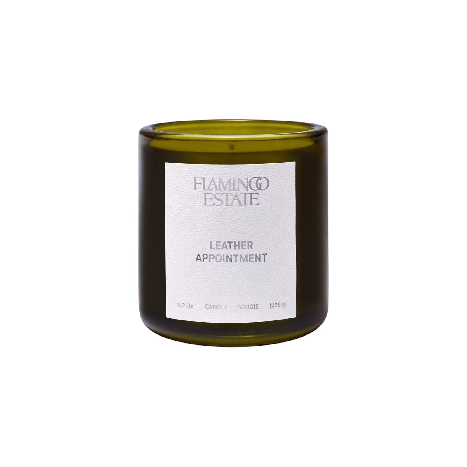 Flamingo Estate Leather Appointment candle in a forest-green fluted glass vessel with a white label.