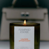 Flamingo Estate Leather Appointment scented candle in a fluted forest-green glass vessel with lit wick