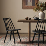 Calimia Home Lewis Windsor chairs in black oak with wire-brushed graining set at a wooden dining table
