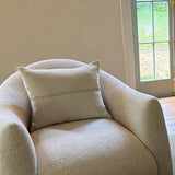 Linear Embroidered Lumbar Pillow by One Bi One — cream linen with misty blue embroidery, styled on an armchair