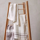 Sir Madam set of two earth-toned linen jacquard tea towels with subtle stripes draped on a wooden drying rack.