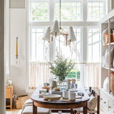 Long Hood Chandelier over a walnut oval dining table by the window at Calimia Home