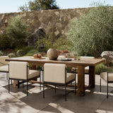 Lumi outdoor dining table set for dinner in front of a stone wall