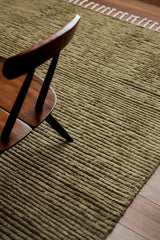 Armadillo Malawi Rug in Olive, a second view of the hand-knotted wool rug in a styled interior