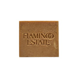 Flamingo Estate Manuka honey soap brick with shea butter and hemp oil, featuring a square shape and embossed logo.