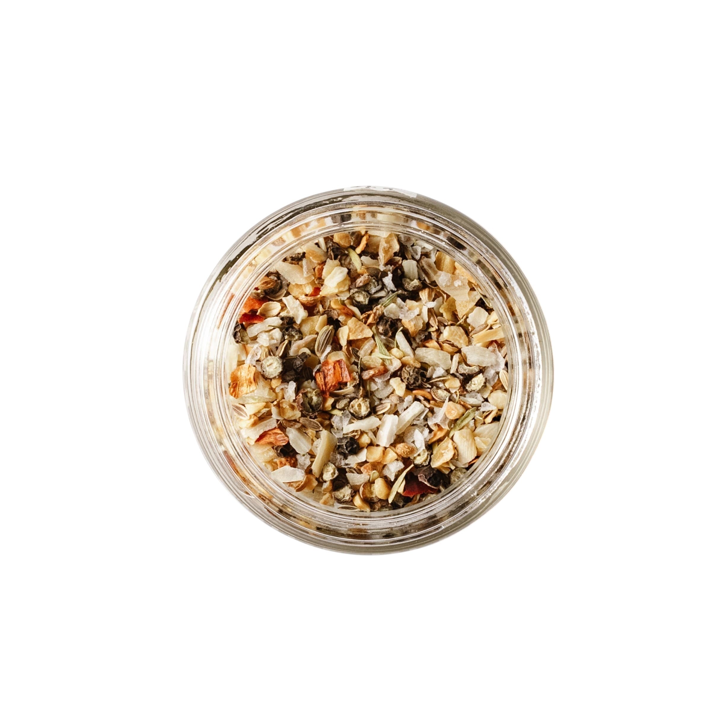Calicutts Montreal spice blend in a glass jar, featuring sea salt, black peppercorns, garlic, onion, and dill seeds.