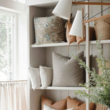 Naia Terracotta Lumbar Pillow — styled detail view showing hand-tied tassel corner and concealed zipper, natural linen texture