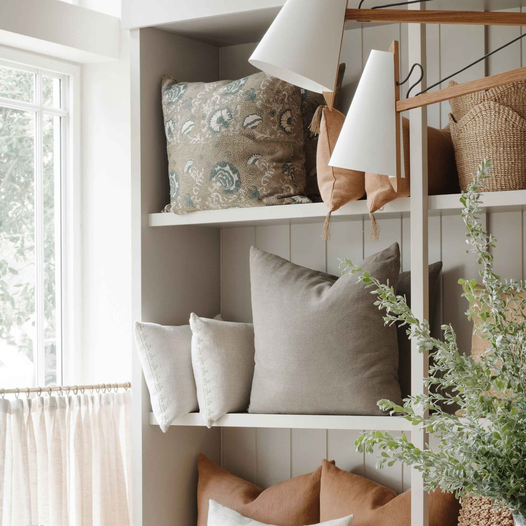 Naia Terracotta Lumbar Pillow — styled detail view showing hand-tied tassel corner and concealed zipper, natural linen texture