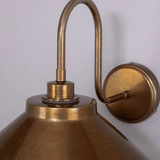 Calimia Home Nerissa industrial wall light in antique brass with a classic swan neck design and metal shade.